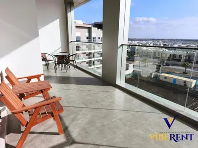 a balcony with a chair and a view of the city at 2BHK near Expo, Al Maktoum Airport, Rooftop Pool in Dubai