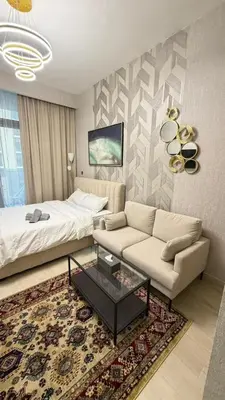 a living room with a bed and a couch at Luxure Studio with Pool View in Dubai