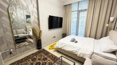a hotel room with a bed and a mirror at Luxure Studio with Pool View in Dubai