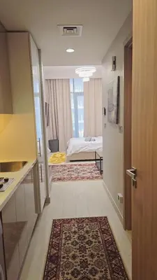 a room with a kitchen and a bedroom with a bed at Luxure Studio with Pool View in Dubai