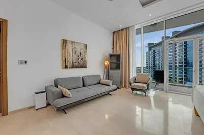 a living room with a couch and a chair at Waves - Grand Palm Escape - Sea-View Massive 1BR Luxury in Dubai