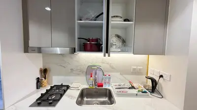 a kitchen counter with a sink and a stove at Luxury Studio in the Heart of Meydan in Dubai