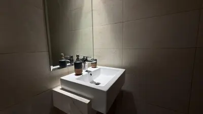 a bathroom with a white sink and a mirror at Luxury Studio in the Heart of Meydan in Dubai