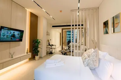 a living room with a white couch and a tv at Stylish central apartment, own Jaccuzi, burj view in Dubai