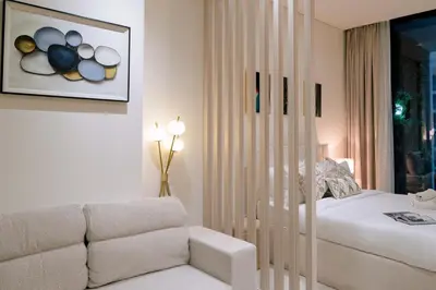 a living room with a bed and a couch at Stylish central apartment, own Jaccuzi, burj view in Dubai