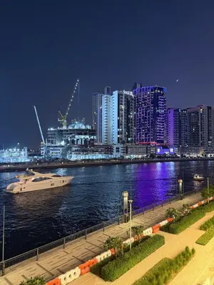 a boat in the water in a city at night at Stylish central apartment, own Jaccuzi, burj view in Dubai