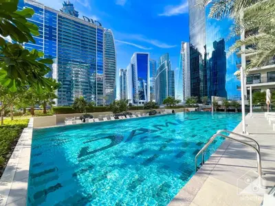 a swimming pool with a city skyline in the background at 4 Person - Resort Canal View - CBD Parking Pool in Dubai