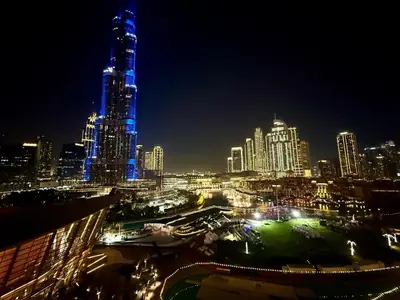 a city at night with a tall building with blue lights at Ultra-Luxury 2BR with Burj Khalifa view Downtown in Dubai