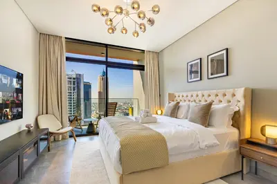 a bedroom with a large bed and a large window at Luxury High-Floor Canal View near Burj Khalifa in Dubai