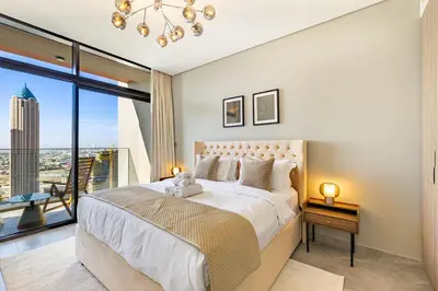 a bedroom with a large bed and a large window at Luxury High-Floor Canal View near Burj Khalifa in Dubai