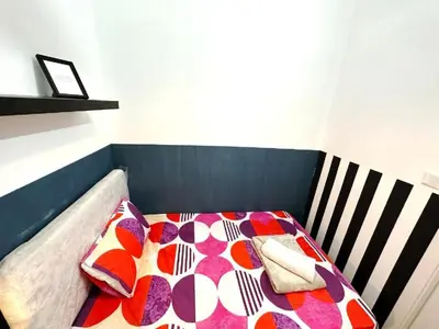 a bed with a colorful blanket and pillows on it at Prime Living Partition Room In Barsha Heights Tecom in Dubai