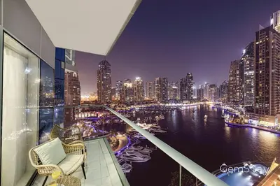 a view of a city at night from a balcony at Beautiful Marina Skyline Serenity Spacious n Bright in Dubai