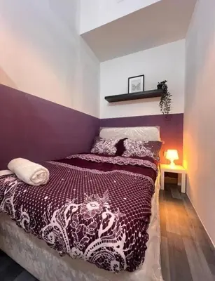 a bedroom with a bed with a purple wall at Mystic Nook Partition Room In Barsha Heights Tecom in Dubai