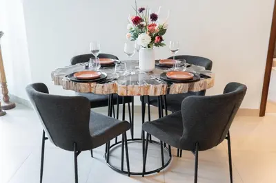 a wooden table with chairs and a vase of flowers at Premium 1BR in Downtown & Direct Access to Metro in Dubai