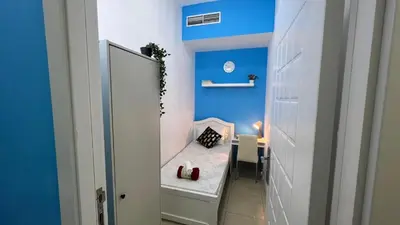 a bathroom with a mirror and a blue wall at Smart Stay Partition Room In Barsha Heights Tecom in Dubai
