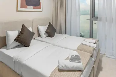 two white beds in a room with a window at Luxury Apartment - Burj Khalifa, Creek - Best View in Dubai