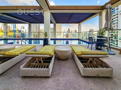 a balcony with a pool and chairs and a table at Apartments at Millennium Atria, Business Bay in Dubai