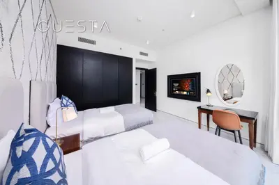 a hotel room with two beds and a desk at Apartments at Millennium Atria, Business Bay in Dubai