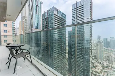 a balcony with a table and a view of a city at High-Floor 3BR with Balcony Overlooking the Marina, Near the Beach, Just Minutes Walk to the Tram, Damac Heights, Dubai Marina by Deluxe Holiday Homes in Dubai