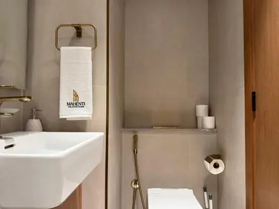 a bathroom with a white sink and a toilet at Mahenti - Stylish Urban Studio with Burj View in Dubai