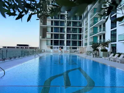 an empty swimming pool in front of a building at Mahenti - Stylish Urban Studio with Burj View in Dubai
