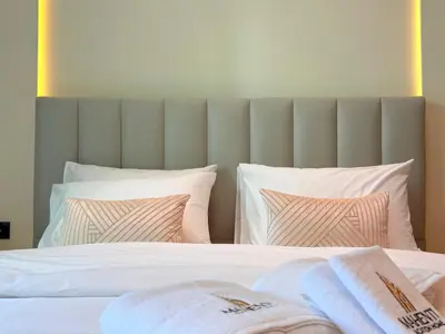 a bedroom with a bed with white sheets and pillows at Mahenti - Stylish Urban Studio with Burj View in Dubai