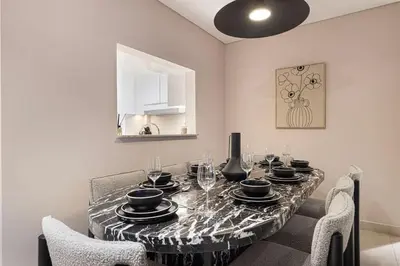a dining room with a table with glasses and chairs at Spacious 4BR for 12 Burj View PS5 Dubai Mall in Dubai