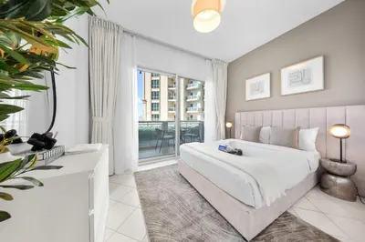 a bedroom with a large bed and a large window at StayShort - Chic studio in Production City that sleeps 4 in Dubai