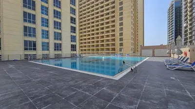 a large swimming pool in the middle of a building at StayShort - Chic studio in Production City that sleeps 4 in Dubai