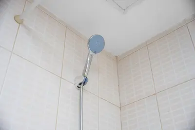 a shower with a shower head in a bathroom at StayShort - Chic studio in Production City that sleeps 4 in Dubai