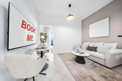 a living room with a white couch and a table at StayShort - Chic studio in Production City that sleeps 4 in Dubai
