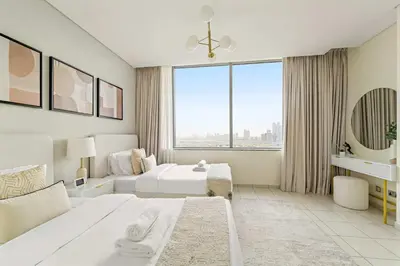 a white bedroom with two beds and a large window at Silkhaus 2BDR Heart of DIFC in Sky Gardens in Dubai