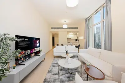 a living room with white furniture and a flat screen tv at Bloomfields Spacious 2BR at Canal Bay in Dubai