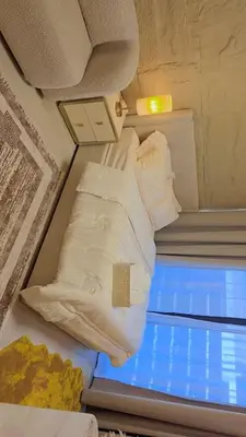 a bed in a small room with white pillows at Luxury Studio with Burj Khalifa View in Dubai