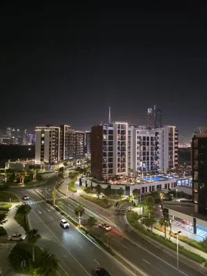 a city at night with cars on a highway at Luxury Studio with Burj Khalifa View in Dubai