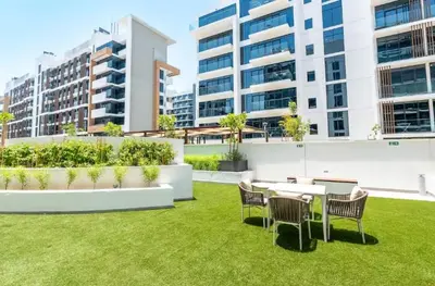 a garden with chairs and tables and buildings at Luxury Studio with Burj Khalifa View in Dubai