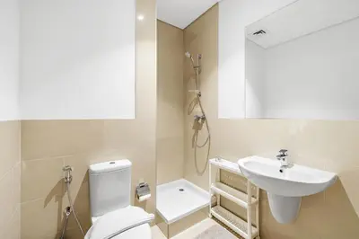 a bathroom with a toilet and a sink and a shower at Upscale 4BR Loft Duplex plus Maid in Creekside, Creek Harbour in Dubai