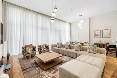 a living room with a couch and chairs and a table at Upscale 4BR Loft Duplex plus Maid in Creekside, Creek Harbour in Dubai