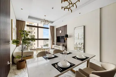 a living room with a dining room table and chairs at Brand New 1BR Near Metro at Avenue Residence in Dubai