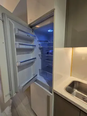 an empty refrigerator with its door open next to a sink at Luxury Studio With Burj Khalifa Views in Dubai