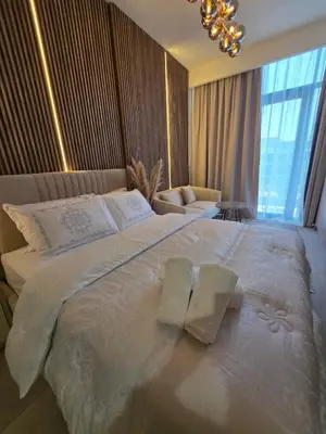 a bedroom with a large white bed with two pillows at Luxury Studio With Burj Khalifa Views in Dubai