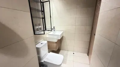 a bathroom with a toilet and a sink and a mirror at Luxury Studio with Pool Views in Dubai