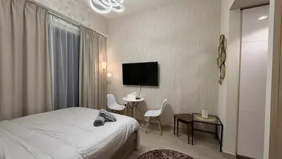 a hotel room with a bed and a table and a tv at Luxury Studio with Pool Views in Dubai
