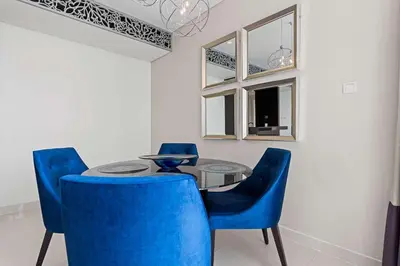 a dining room with blue chairs and a table at Elegant 2BR Downtown Apartment - Near Burj Khalifa in Dubai