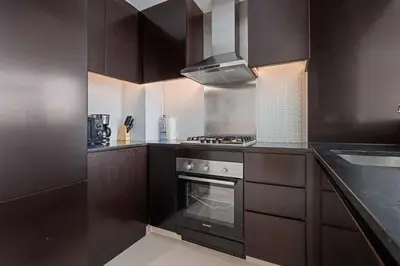 a kitchen with dark brown cabinets and an oven at Elegant 2BR Downtown Apartment - Near Burj Khalifa in Dubai