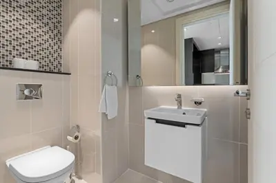 a bathroom with a toilet and a sink and a mirror at Elegant 2BR Downtown Apartment - Near Burj Khalifa in Dubai