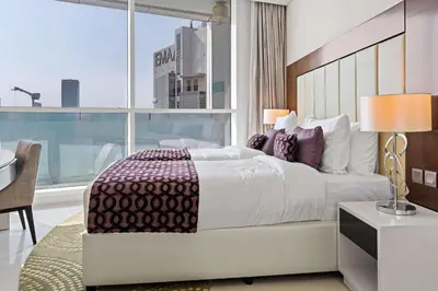 a bedroom with a bed and a desk and a window at Elegant 2BR Downtown Apartment - Near Burj Khalifa in Dubai