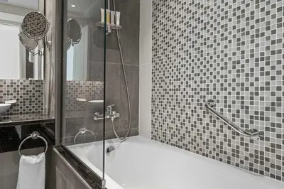 a bathroom with a shower with a tub and a sink at Elegant 2BR Downtown Apartment - Near Burj Khalifa in Dubai