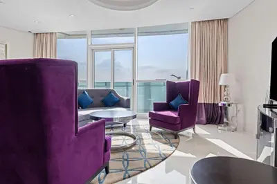 a living room with purple chairs and a table at Elegant 2BR Downtown Apartment - Near Burj Khalifa in Dubai
