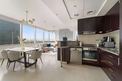 a kitchen with a table and a dining room at Silkhaus Expansive 2BDR in DIFC Sky Gardens in Dubai